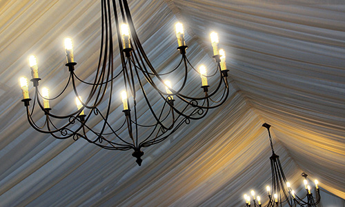 A billowing tent liner with delicate black chandeliers create an elegant scene.