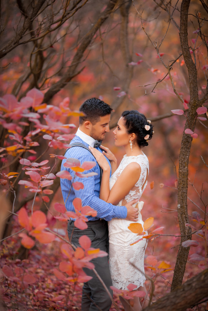 Wedded couple surrounded by fall foliage.