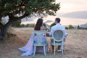 A newly wedded couple sits together under a tree.
