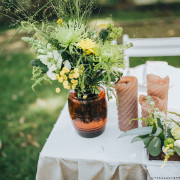 An outdoor wedding table set with flowers and candles.