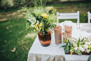 An outdoor wedding table set with flowers and candles.