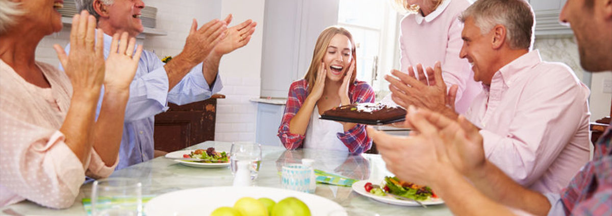 A group of people enjoying a party and sitting around a table.