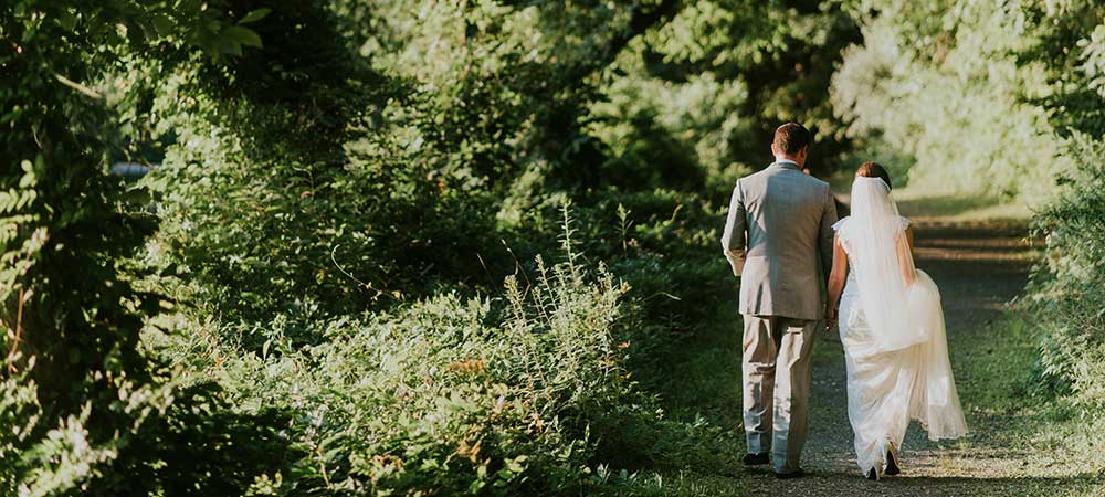 Image of wedding couple walking down a path.